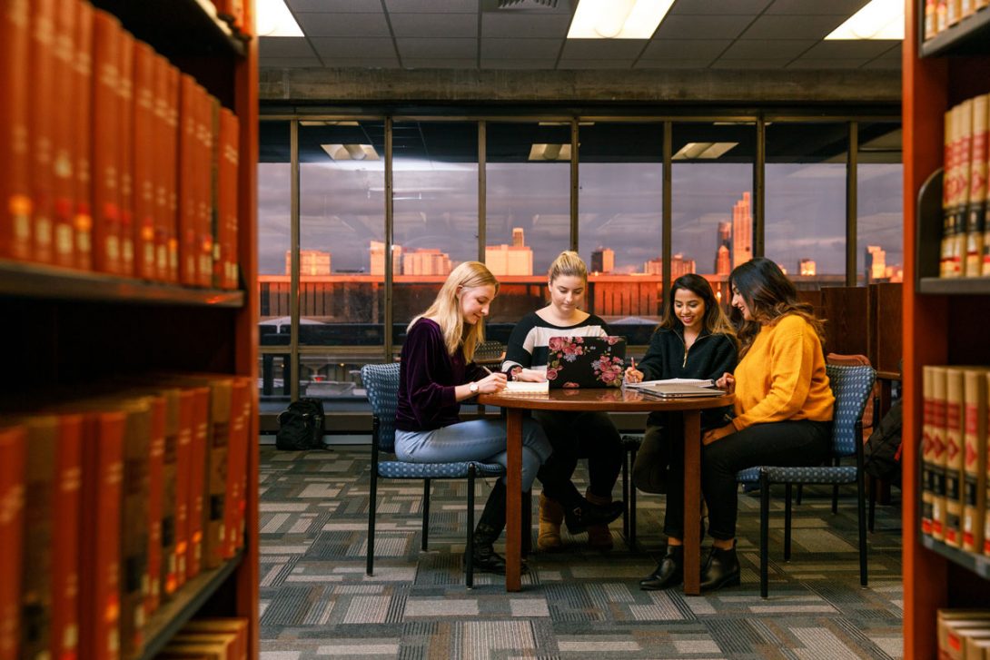 Women in library at a table with laptops
