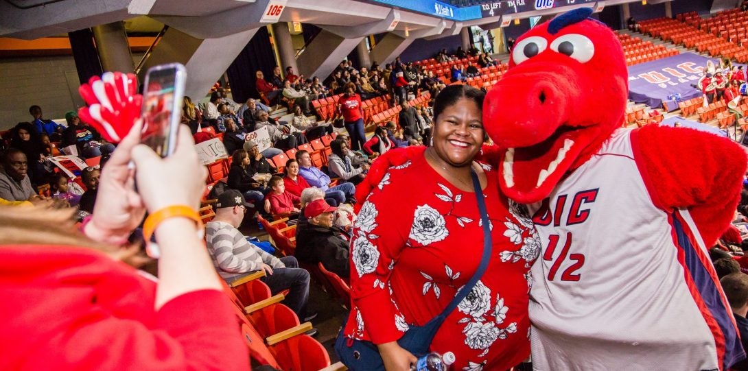 UIC alumna with Sparky mascot at annual pre-game basketball social