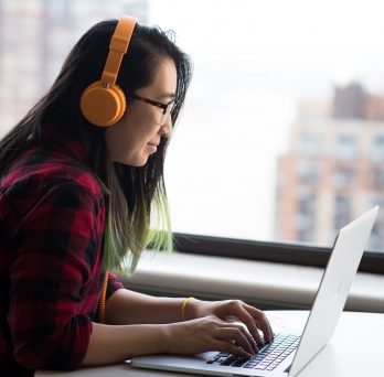 Woman at laptop with headphones 