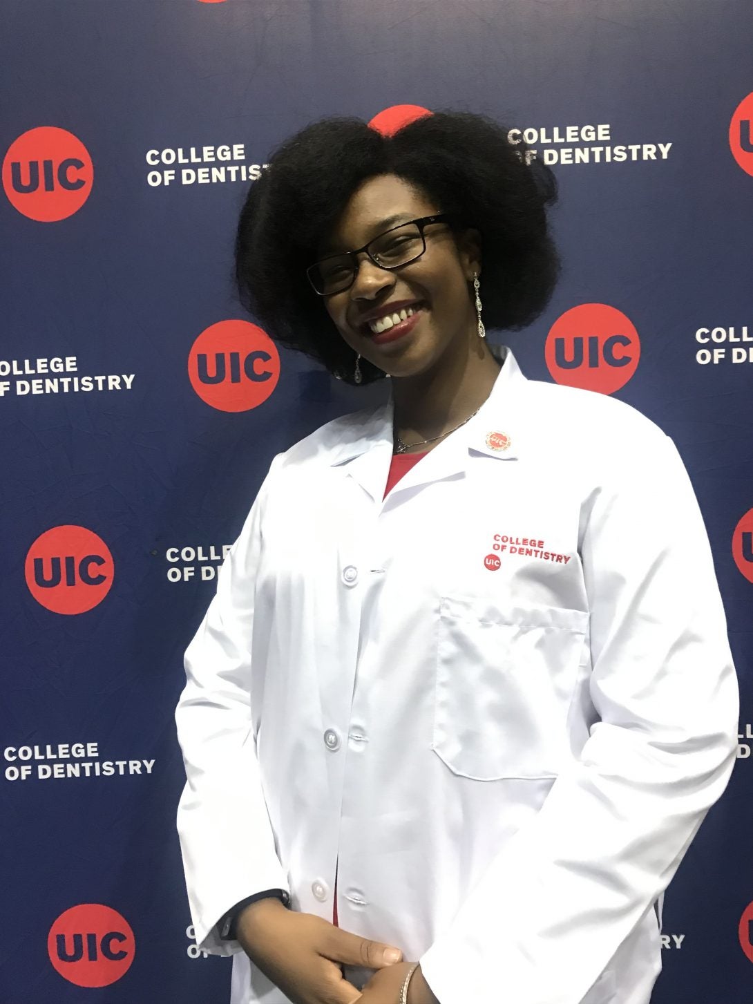 Woman in lab coat smiling for camera