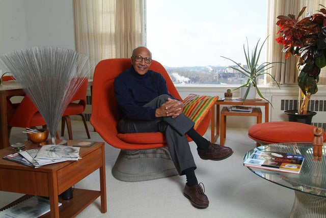 Charles Harrison seated on an orange chair in his home