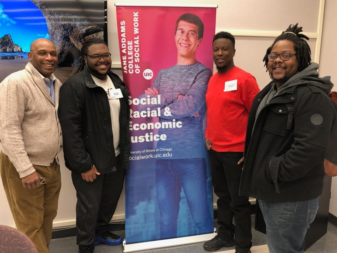 Four men standing and smiling for the camera