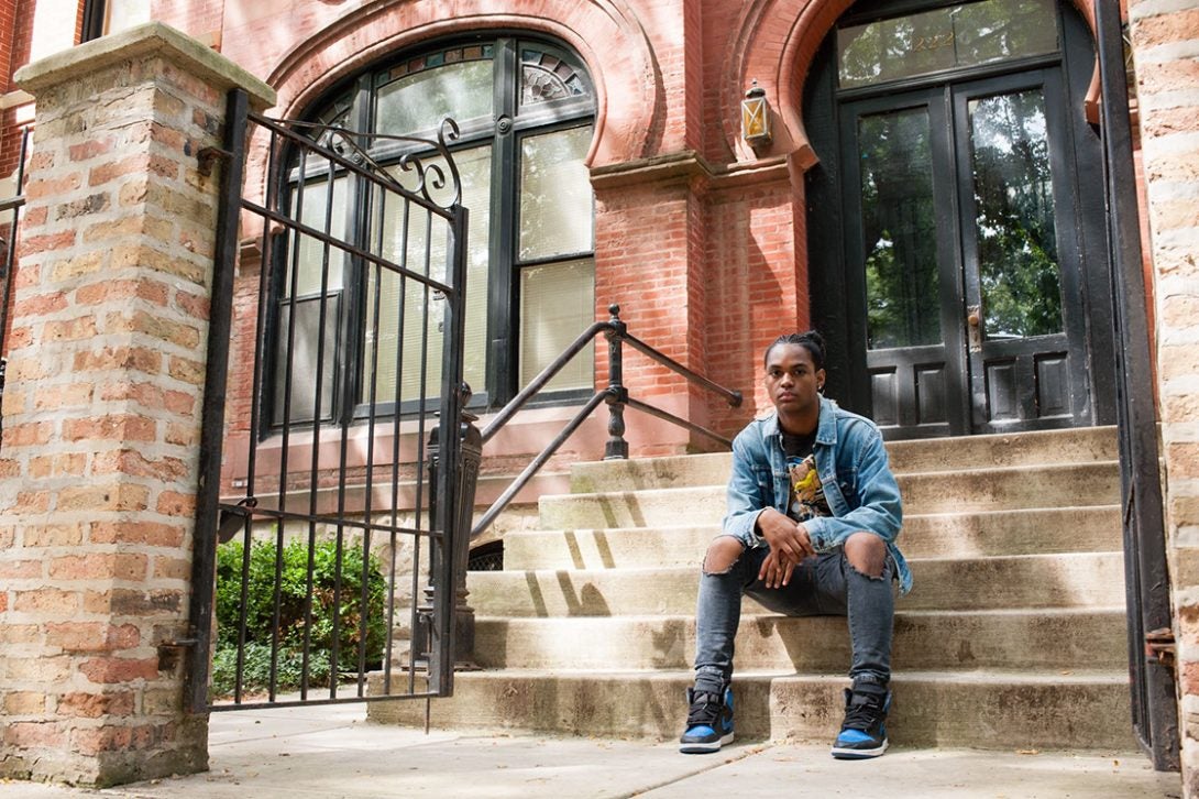 A man sits on the steps of a home.