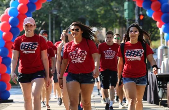 Students walking through campus wearing red UIC t-shirts
