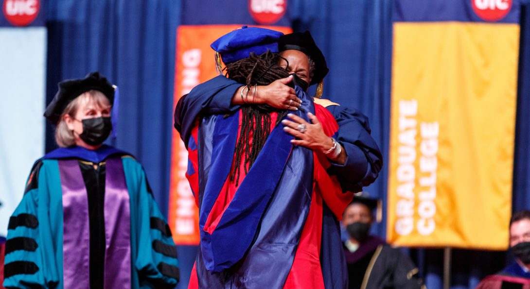Two people hugging in graduation gowns
