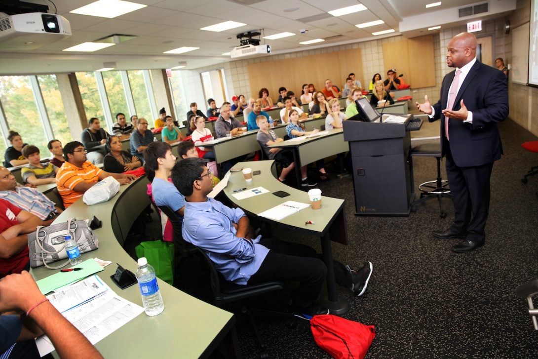 A man lecturing in a classroom full of students