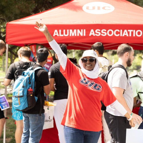 a staffer in front of an alumni tent