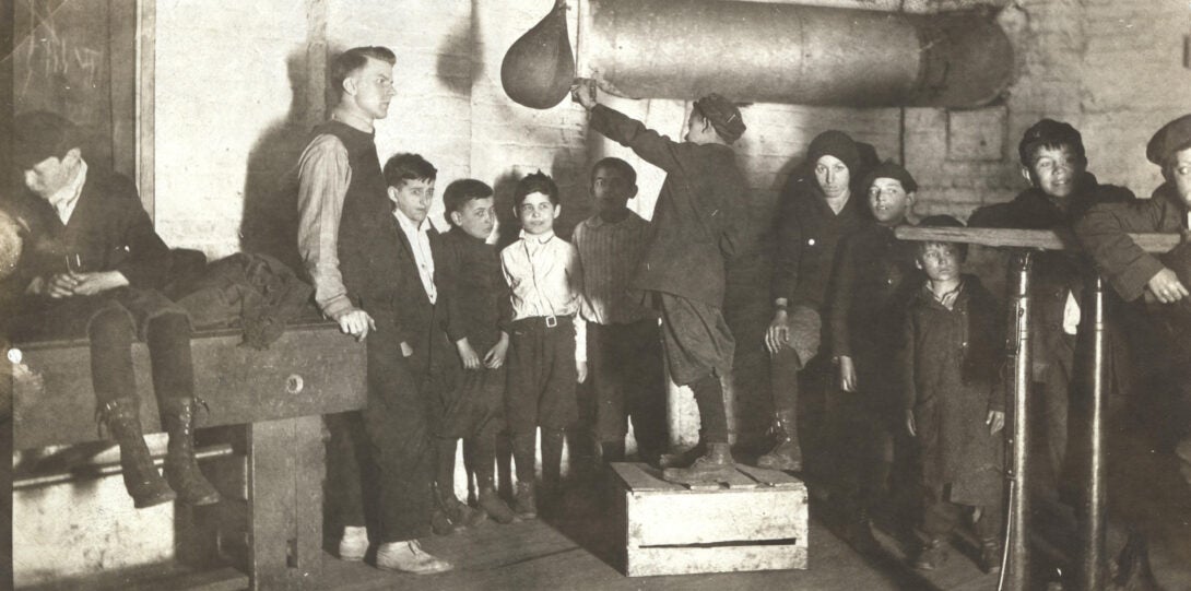 Boy demonstrating a punching bag to young boxers